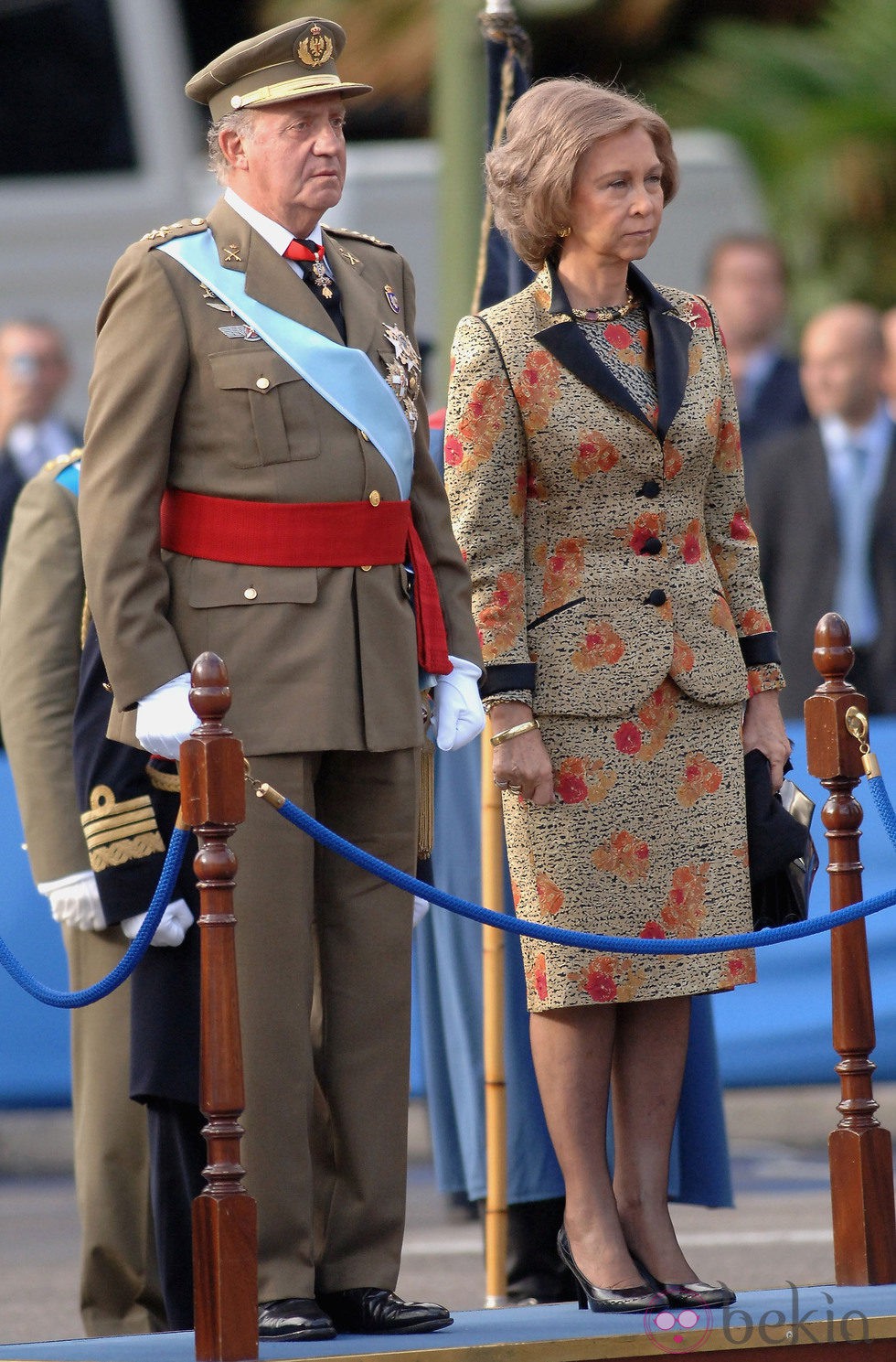 Look de la reina Sofía con vestido lady de color beige, detalles jaspeados en negro y estampados florales en tonos naranja