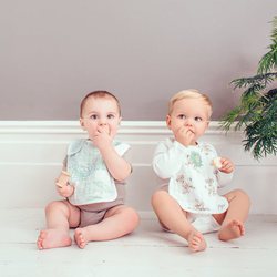 Baberos blancos con estampados de plantas y Simba  de la colección de El Rey León de Aden + Anais