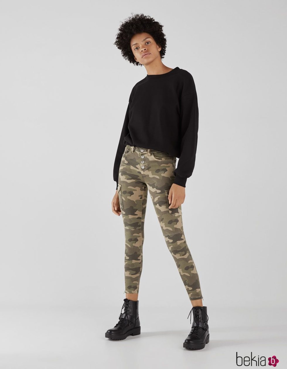 Modelo con unos pantalones con estampado militar de la colección de primavera 2019 de Bershka