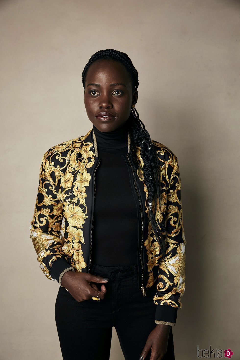 Lupita Nyongo vestida de negro y chaqueta de flores