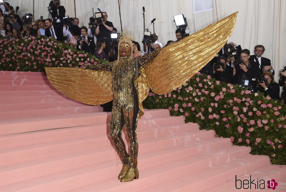 Billy Porter con un mono dorado con grandes alas en la alfombra roja de la Gala MET 2019