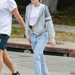 Kristen Stewart con un look sporty chic de lujo con vaqueros lavados rectos y crop top con sudadera de cremallera en Los Ángeles