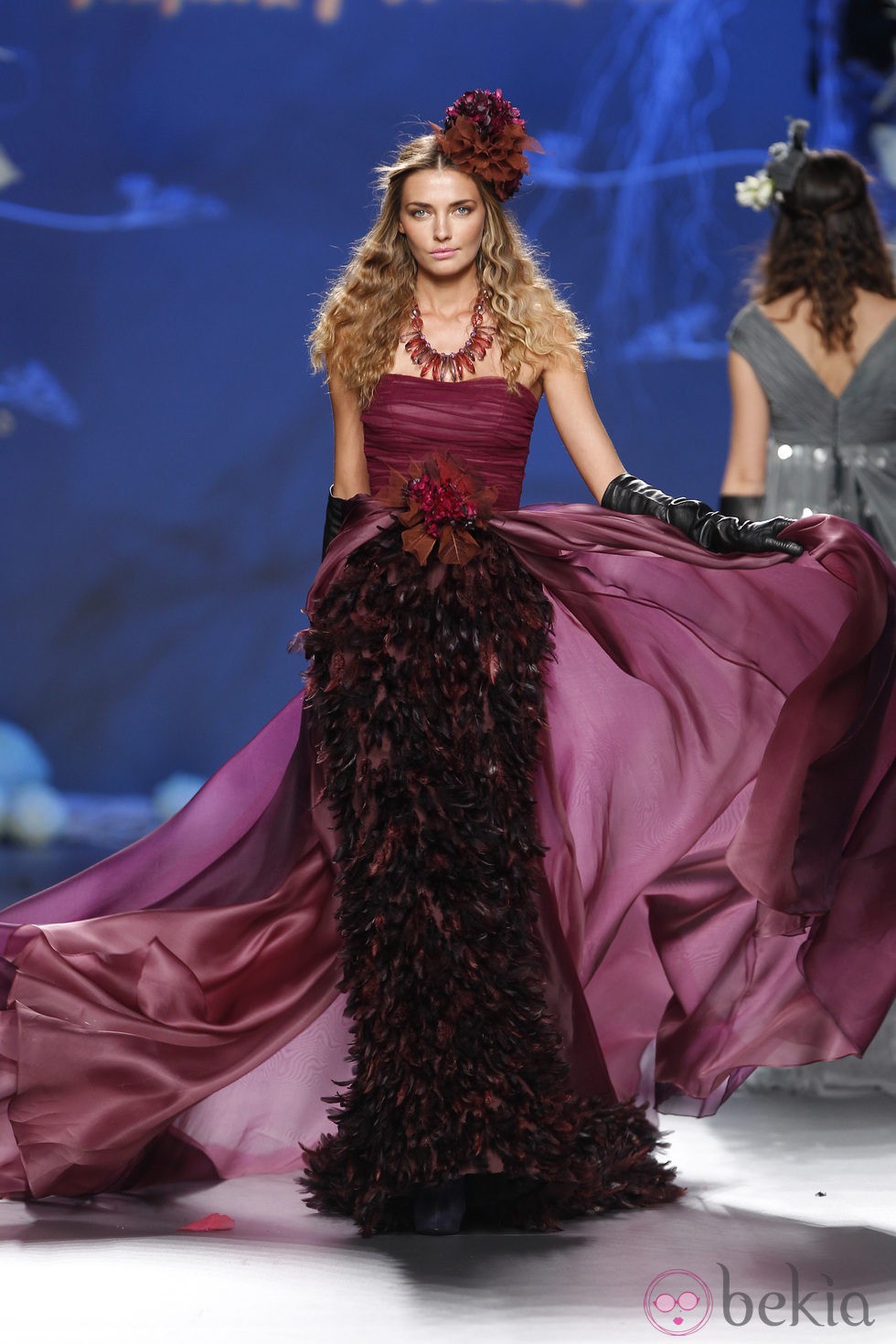 Desfile de Francis Montesinos en la Fashion Week Madrid: vestido largo burdeos con plumas del mismo tono