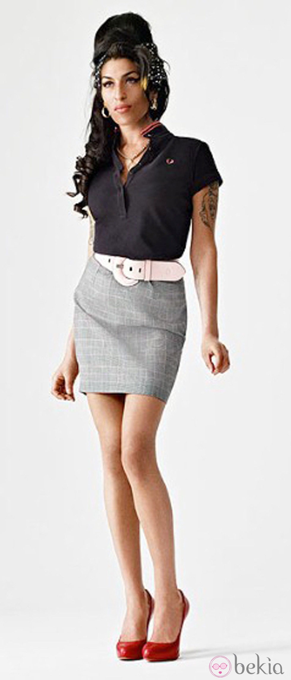 Amy Winehouse con falda gris y polo azul marino para Fred Perry