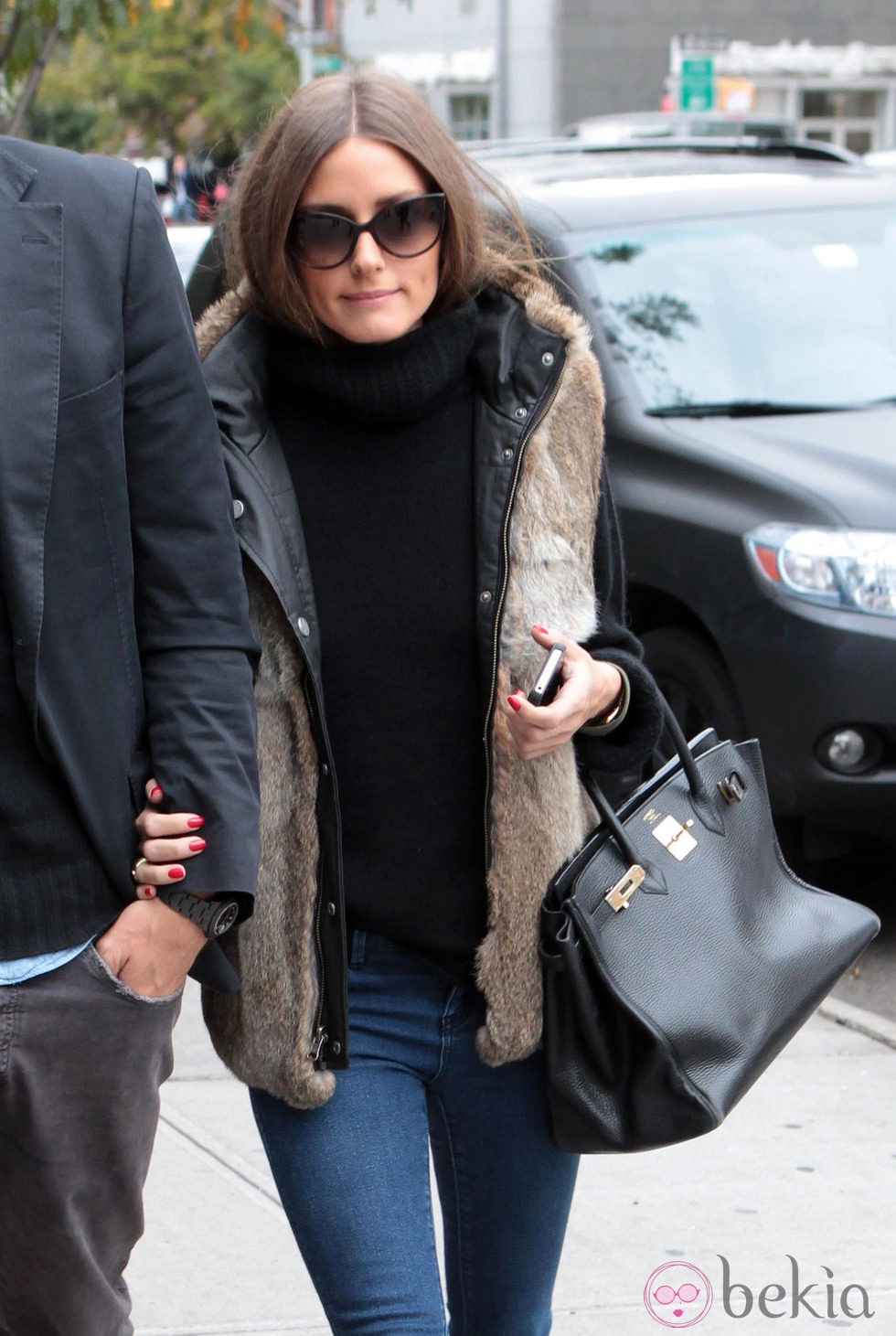 Olivia Palermo con jersey negro y chaleco de pelo