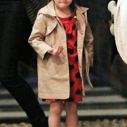 Suri Cruise con gabardina y vestido rojo de corazones