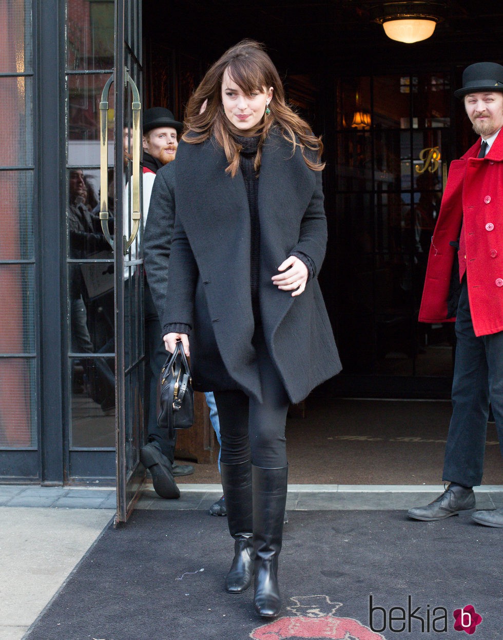 Dakota Johnson protegiéndose del frío con un look total black