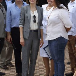 La Reina Letizia con un traje gris de Hugo Boss y una camisa de algodón blanca en El Salvador