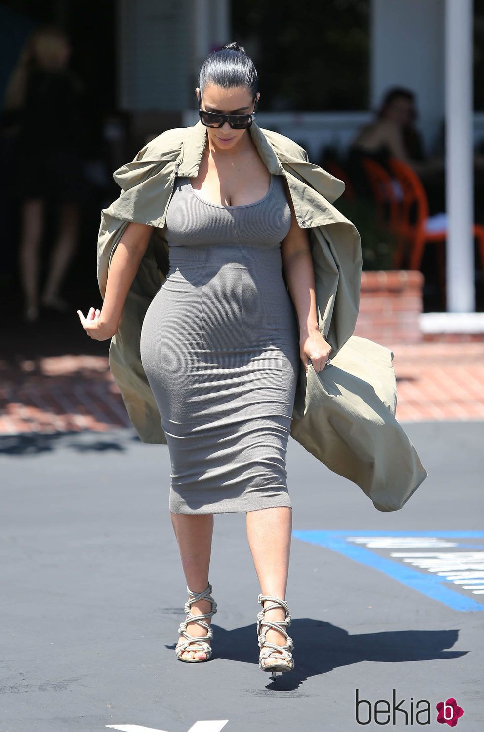 Kim Kardashian con vestido gris y gabardina en su segundo embarazo