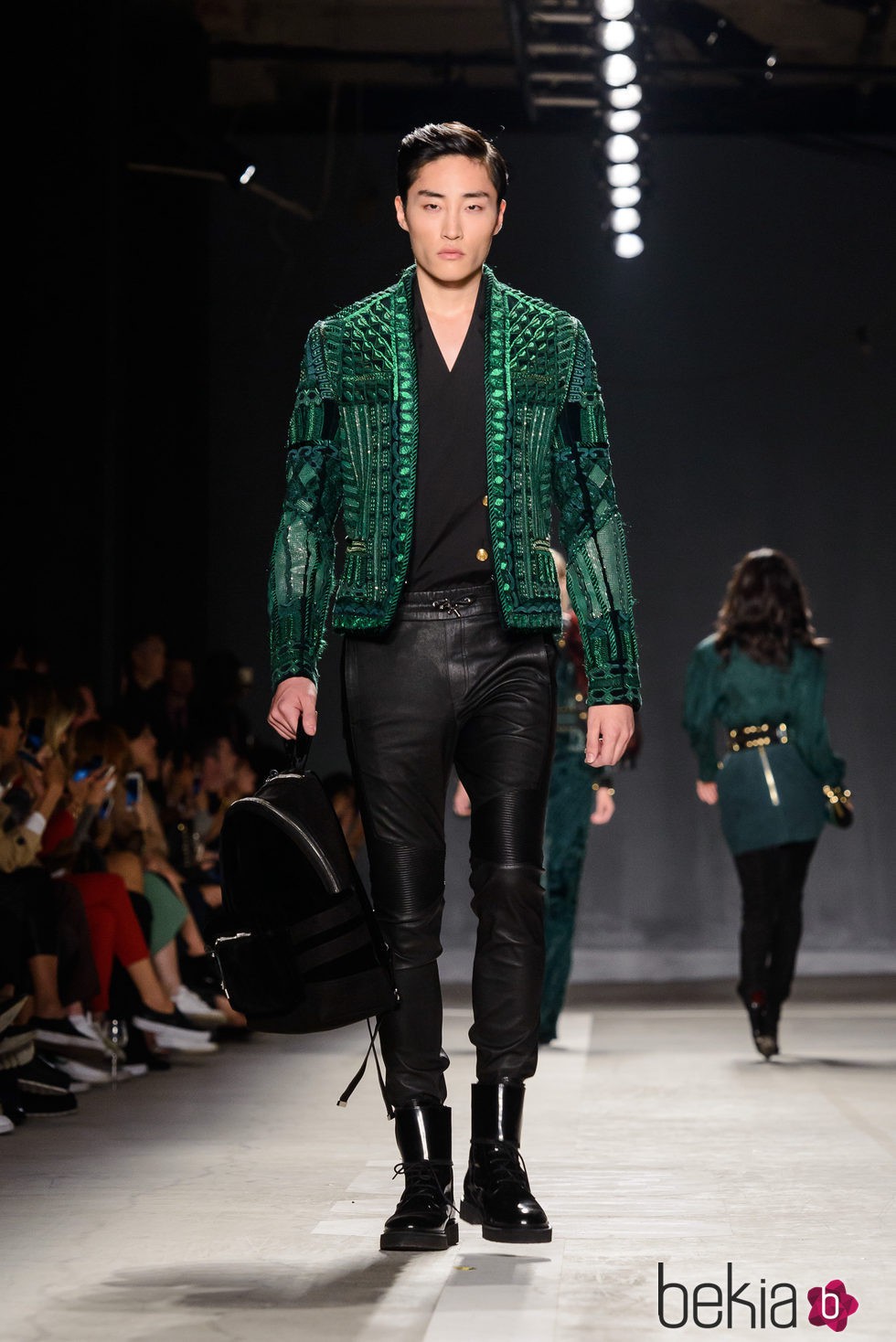 Modelo con chaqueta verde y pantalón negro en el desfile de Balmain para H&M en Nueva York