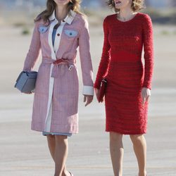 Rania de Jordania con abrigo en tweed y la Reina Letizia con vestido rojo de Felipe Varela en la llegada de Rania al aeropuerto de Madrid