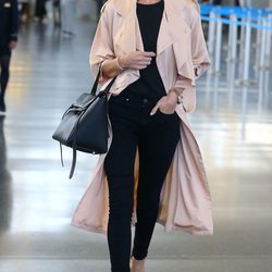 Rosie Huntington con aoutfit negro y abrigo color  rosa cuarzo