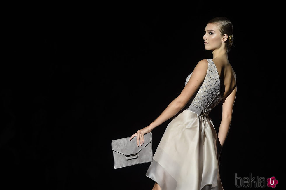 Modelo con un vestido en color crema en el desfile de Hannibal laguna